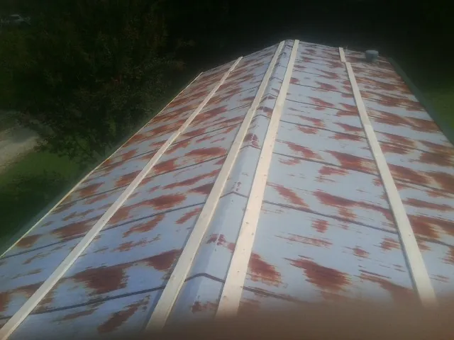 Rusted metal roof panels with new wood purlins before replacement — Storm Damage Roof Repair in West College Corner by Roofing Brothers