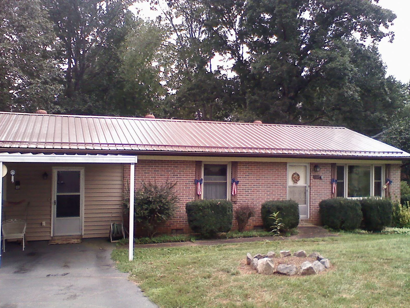 Bronze metal roof and carport on a brick ranch home — Roof Repair work by our crew in West College Corner